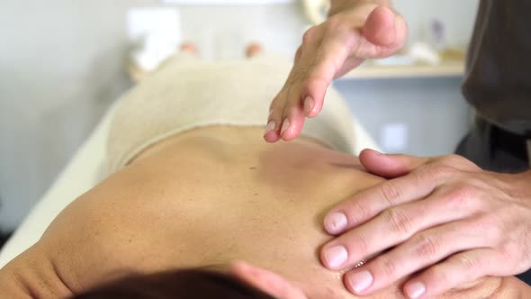 Physiotherapist giving back massage to a woman alt
