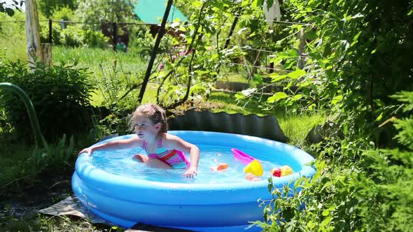 Cheerful Girl In Inflatable Pool In Summer Garden - 1