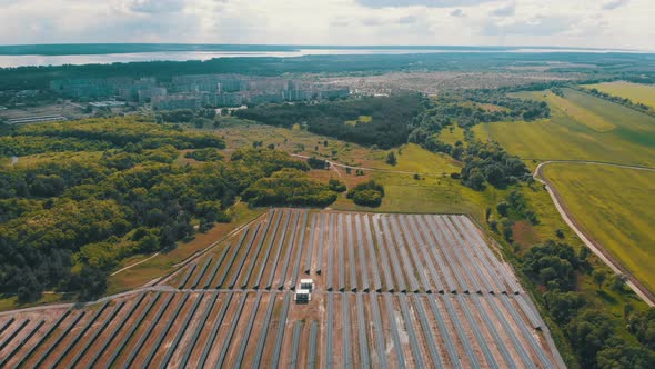 Aerial View on Solar Power Station in Green Field Near Small City at Sunny Day alt