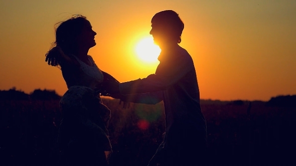 Silhouette Of Couple Hugging Whirl In Happiness