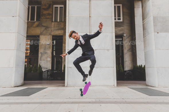 Young handsome Asian model jumping with his skateboard - Stock Photo - Images