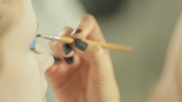 Application Of Blue Shadows On Eyelids alt