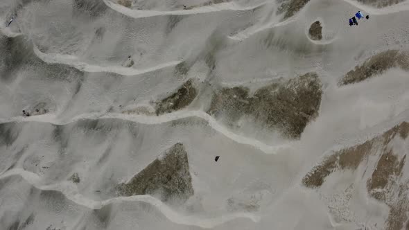 Overhead drone shot of stunning sand dunes and people soaking up the sun at Nye Beach in Newport, Or alt