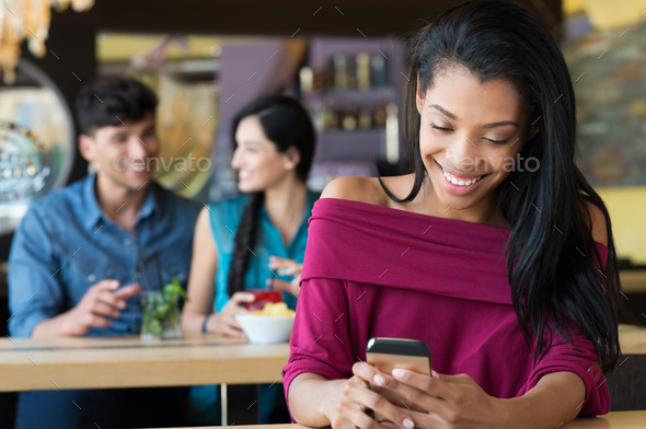 Woman texting on phone at coffee bar - Stock Photo - Images
