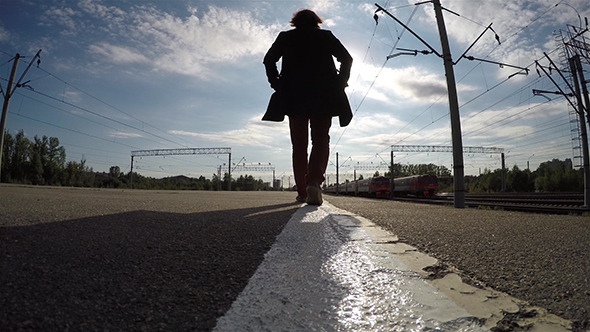 Silhouette of Man Walking On Edge Of Platform