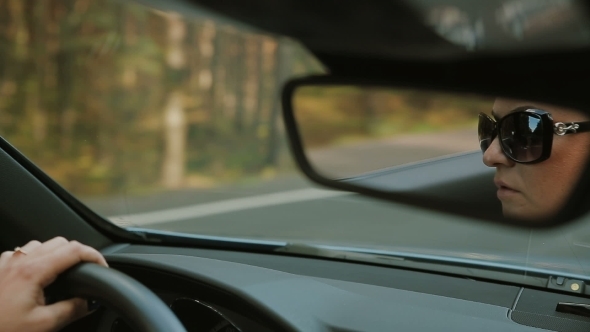 Female Driving a Luxury Open Top Car alt