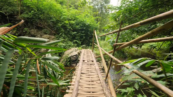 Walking at Bamboo Bridge Over the River in Tropical Rainforest Jungle. Slowmotion Wide Angle POV alt