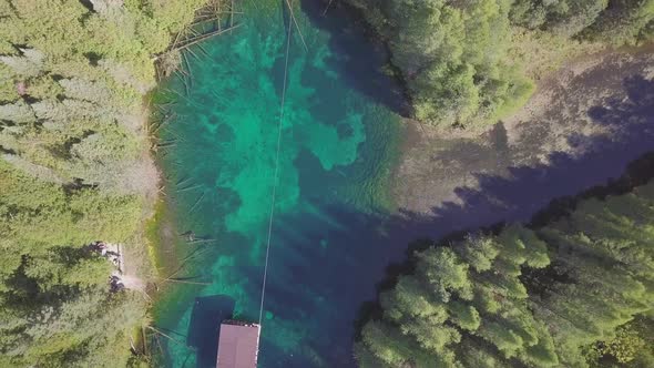 Aerial drone shot flying over crystal blue water of Kitch-iti-kipi, the big spring, in Palms Book St alt