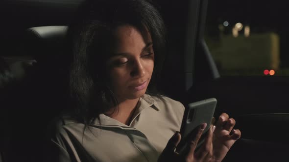 Woman Using Smartphone At Backseat alt