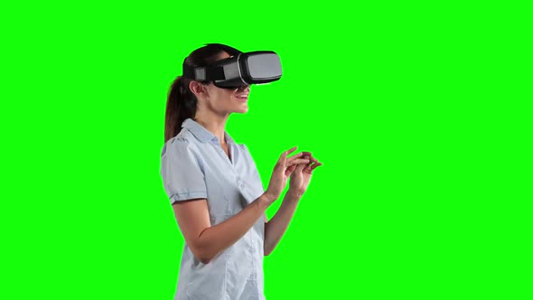 a Caucasian woman wearing 3D goggles in a green background