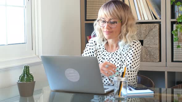 Adult woman type on laptop computer and smile happy for smart working free office home activity