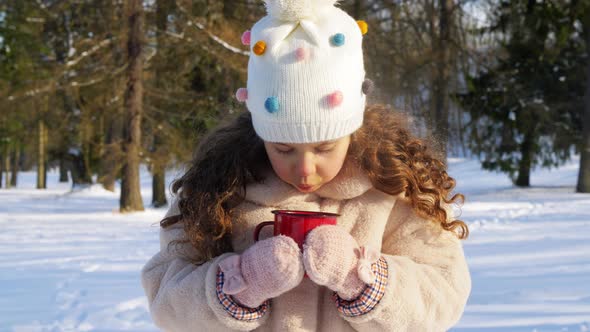 Little Girl with Cup of Hot Tea in Winter Park alt