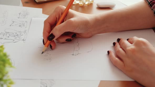 Woman Designer sketching on white paper, working from home office