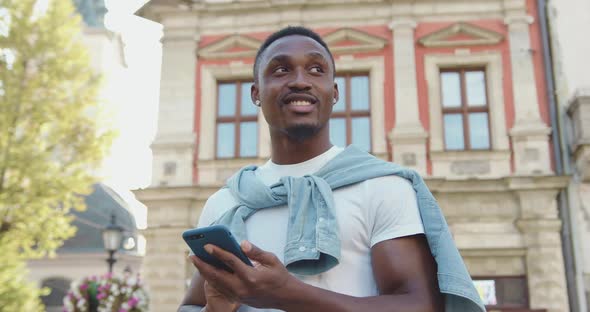 African American with Stylish Beard which Standing on the Street and Typing Message alt