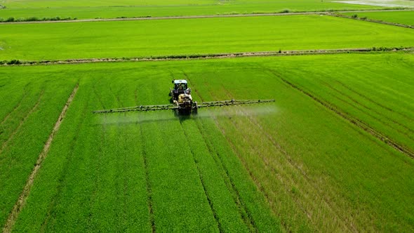 Tractor Sprayer Fertilizer, Herbicide, Pesticide on Agriculture Farm Field alt
