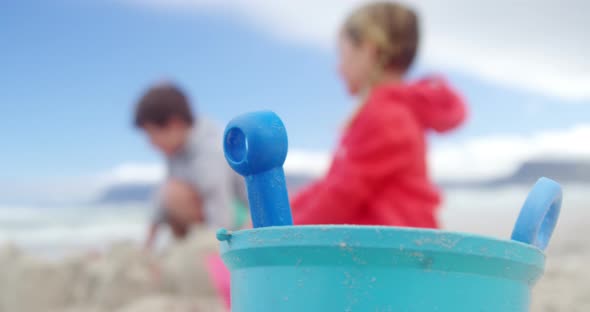 Kids making making sand castle at beach alt
