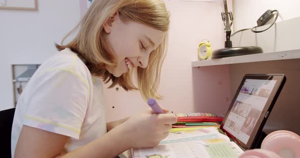 The Teenager is at Home Drawing at the Table the Children's Room in Pink Colors alt