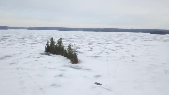 Aerial View Rising to Reveal Large Frozen Lake in Winter