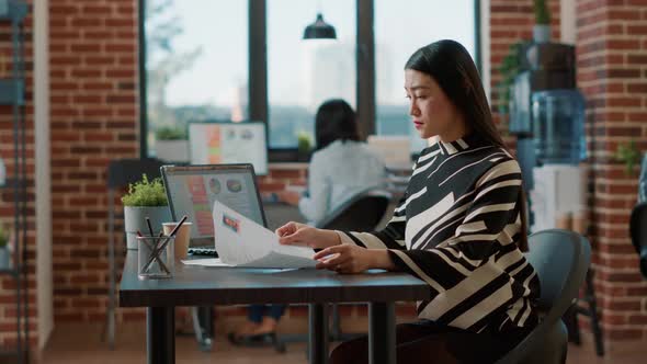 Portrait of Asian HR Employee Analyzing Cv Information of Candidates alt
