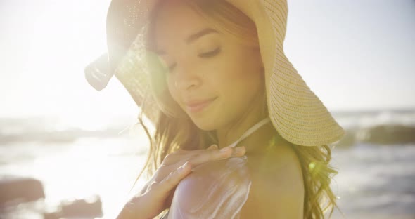 Woman applying sunscreen lotion on the beach 4k