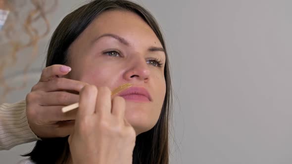 Professional Cosmetologist Performs Wax Epilation on the Patient's Upper Lip alt