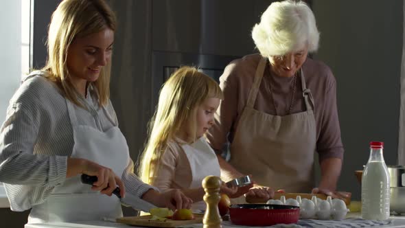Little Girl Cooking with Mom and Grandma alt