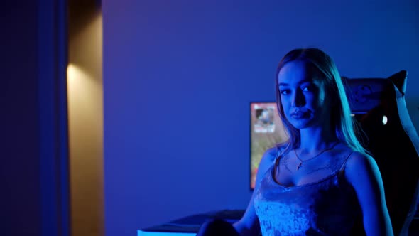 A Gamer Girl Walks in the Room with PC and Starts Playing a Shooter Game alt