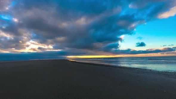 Time lapse of dark clouds moving over a beach, during sunset, on Langeoog island alt