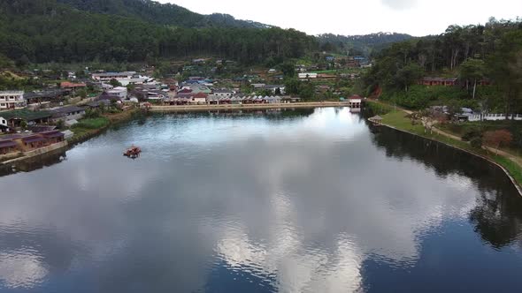 Aerial view by drone of a small boat sailing in a beautiful lake