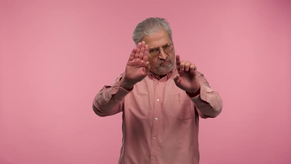 Portrait of an Elderly Man with Glasses Strictly Gesturing with Hands Shape Meaning Denial Saying NO alt