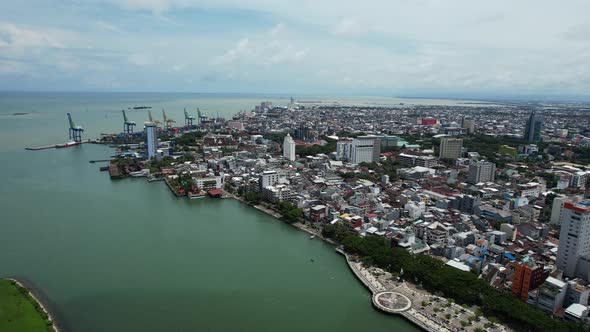 aerial view of Makassar city Sulawesi Indonesia with large buildings and a port in the distance with alt