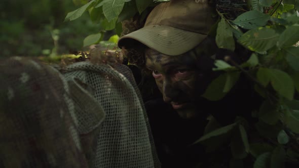 Closeup of Sniper in Disguise Sniper Coat Applying Camo Paint on Face alt