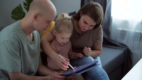Kid with Cochlear Implants Playing with Tablet Pc at Home alt