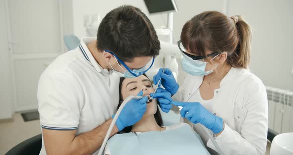 Dentist and Assistant Working with Patient