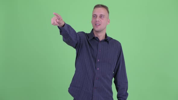 Happy Handsome Businessman Pointing Finger and Looking Surprised alt
