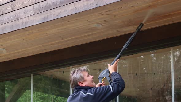 Man Cleaning Walls and Floor with High Pressure Power Washer