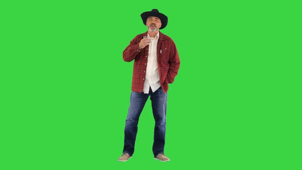 Bearded Man in Cowboy Hat Drinking Expensive Whisky on a Green Screen Chroma Key alt