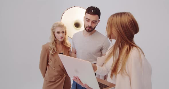 Girl Stylist Together With A Photographer Working On Creating A Fashionable Image For A Model