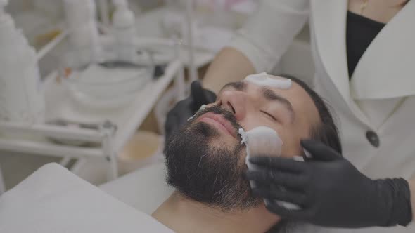Closeup of Young Man Face with Cleansing White Mask on Face alt