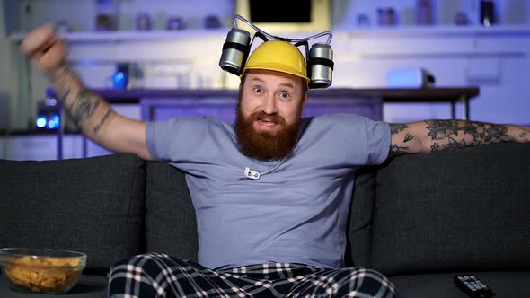 Adult man sitting on the sofa and watching football