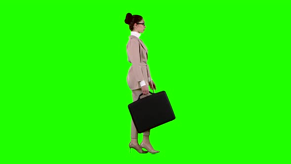 Girl with Cases in Her Hands Goes To Work. Green Screen. Side View. Slow Motion alt