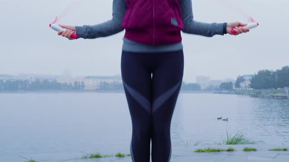 Slender Girl in Warm Sportswear is Jumping Rope alt
