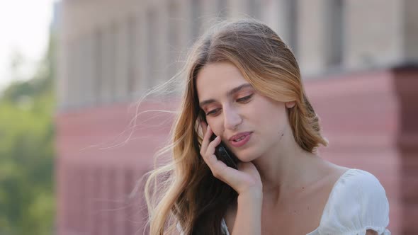 Emotional Female Student in Summer Dress Share Amazing News with Friend By Phone Hold Device By Ear alt