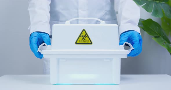 Doctor or Scientist Wearing Sterile Gloves Closes a Container for Transportation with Smoking alt
