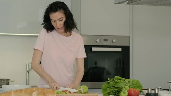 Young American Woman is Preparing Salad and Dancing at Table in Home Kitchen Rbbro