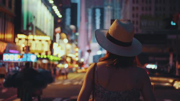 Young girl with retro camera in Times Square at night alt