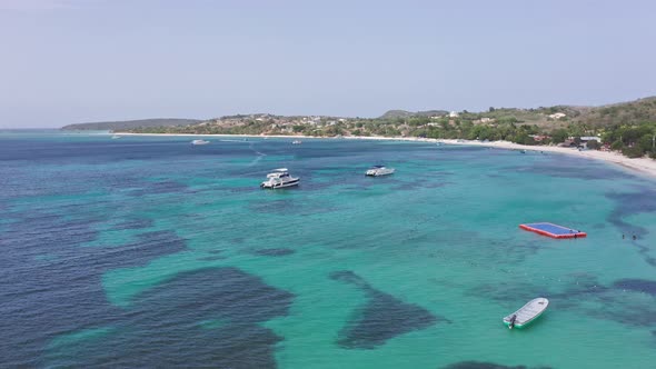 Lovely turquoise Caribbean with pleasure boats off tropical beach; aerial alt