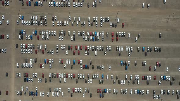 Aerial View of a Quadcopter Flying Over a Huge Parking Lot. Many Cars Are Parked in the Parking Lot