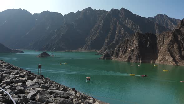 Cinematic view of the Hatta Dam lake with boats. Static alt