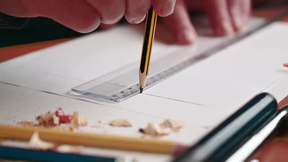 an architect draws a new project with a pencil and a ruler. An engineer makes a drawing.